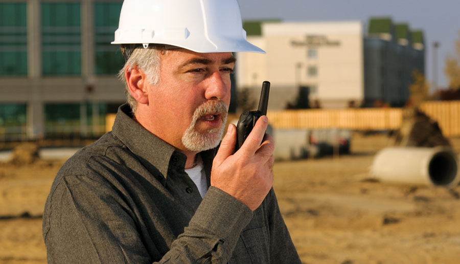 Contremaître de construction utilisant une radio bidirectionnelle à batterie 